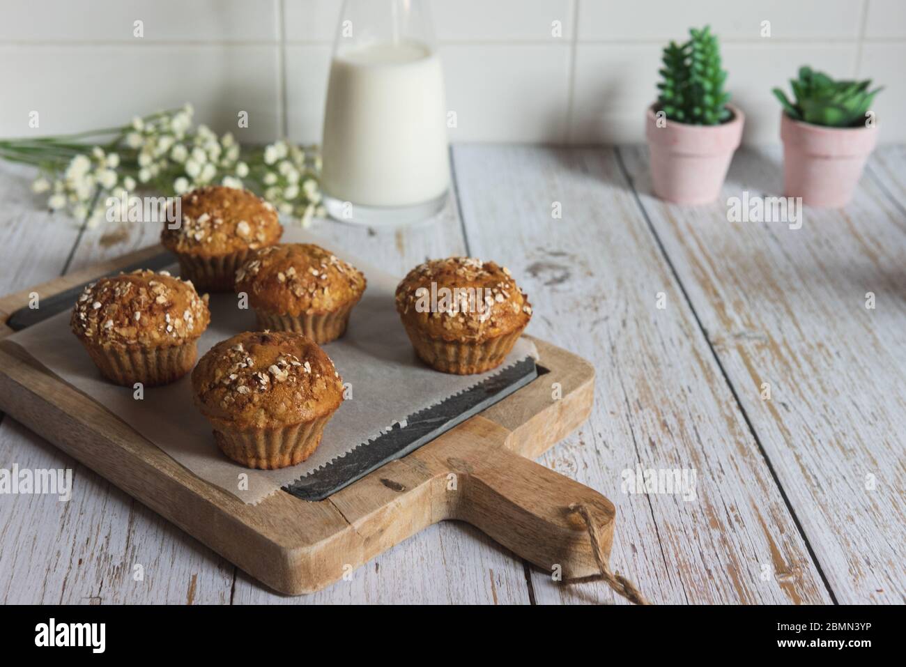 Freschi e fatti in casa deliziosi muffin carota decorato con fiocchi d'avena e zucchero di canna su tavolo rustico, spazio per fotocopie Foto Stock