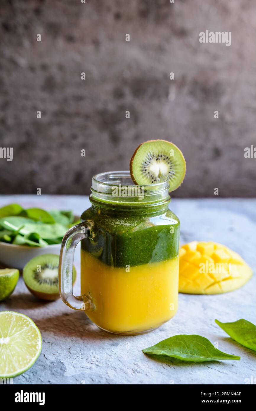 Mango fresco a strati, spinaci, kiwi e frullato di lime Foto Stock