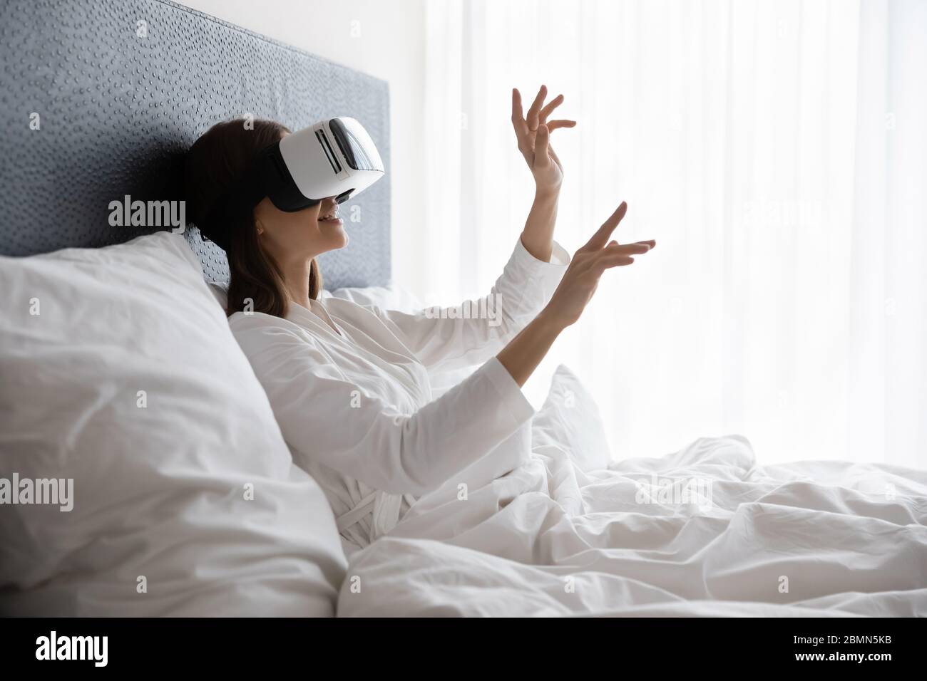 Donna che indossa una cuffia per realtà virtuale goditi un'esperienza 3D immersivo totale Foto Stock