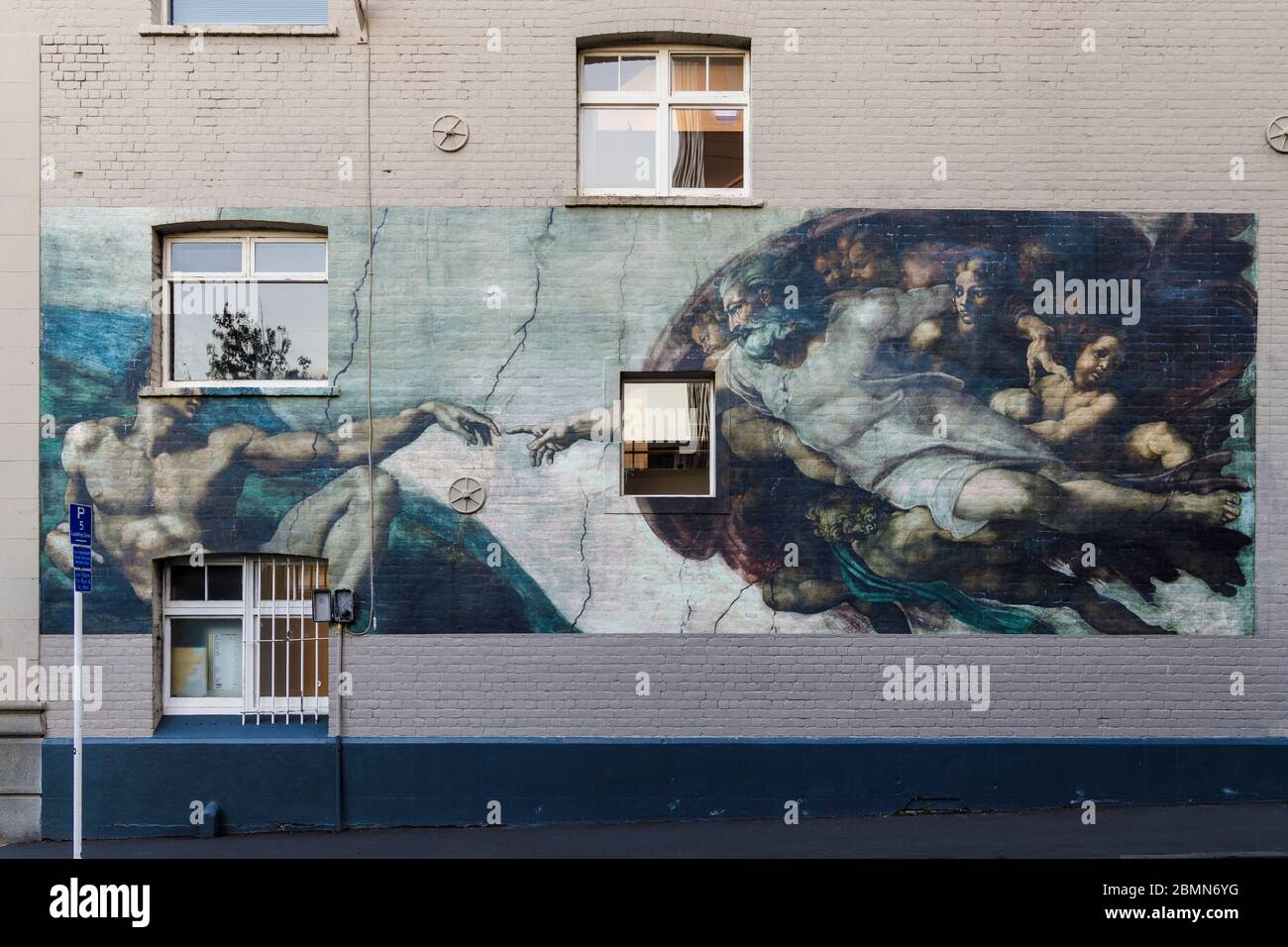 Una copia del 2014 della creazione di Adamo di Michelangelo sul lato di un edificio ad Auckland, Nuova Zelanda. Foto Stock