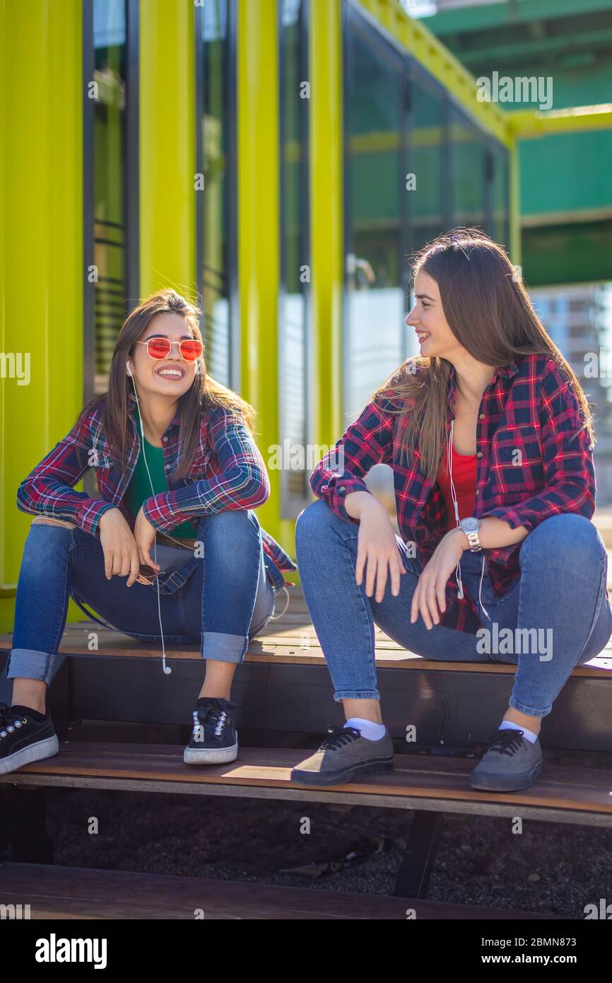 I migliori amici per sempre seduti insieme e parlando in ambiente urbano Foto Stock
