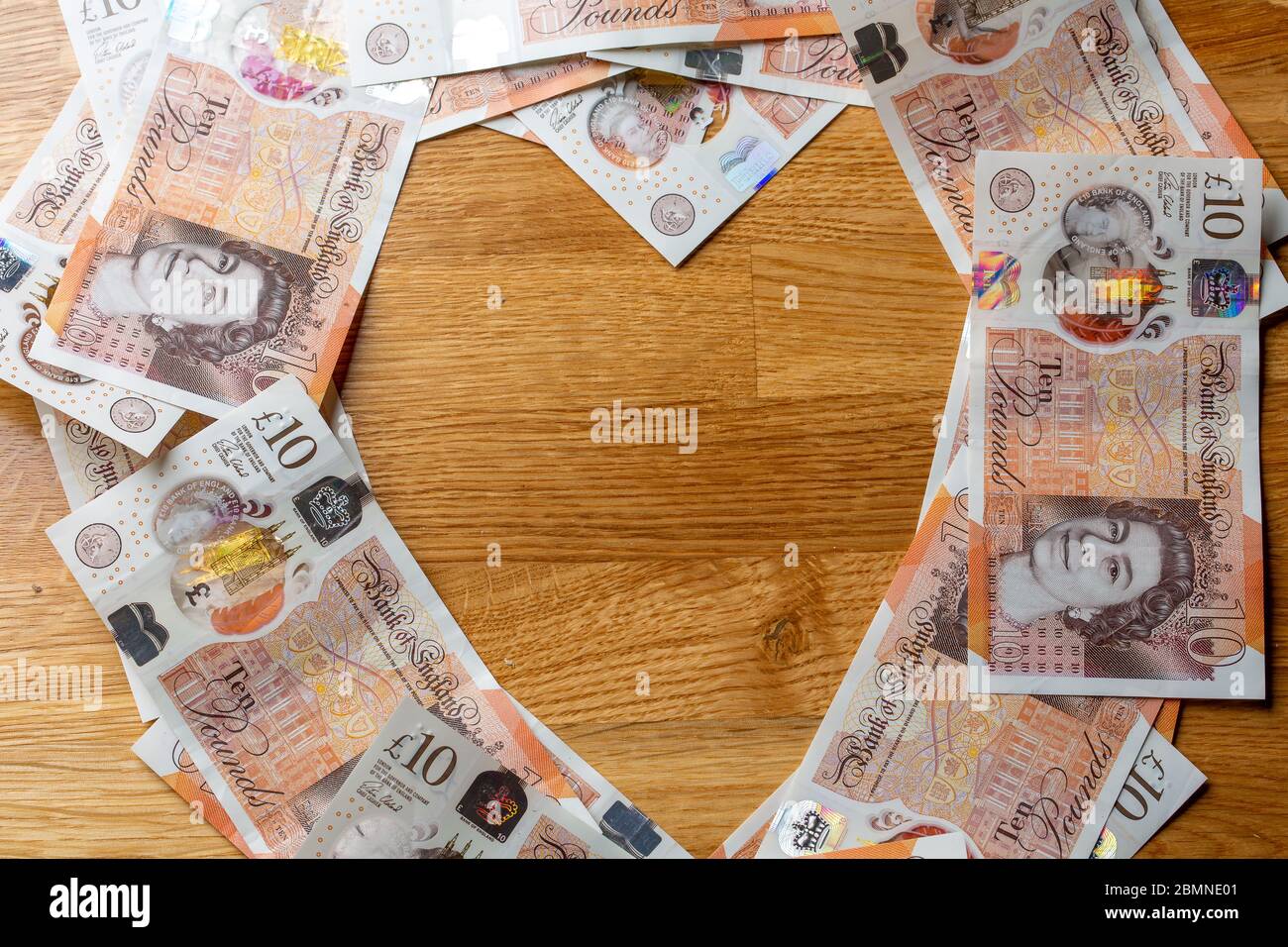 Dieci banconote da libbra a forma di cuore, in contanti sterling britannico Foto Stock