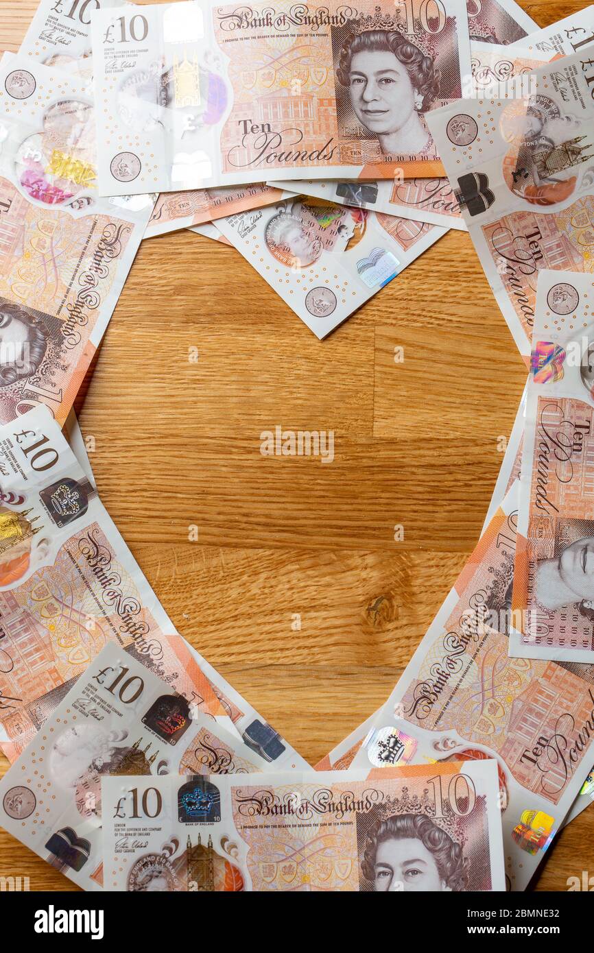 Dieci banconote da libbra a forma di cuore, in contanti sterling britannico Foto Stock