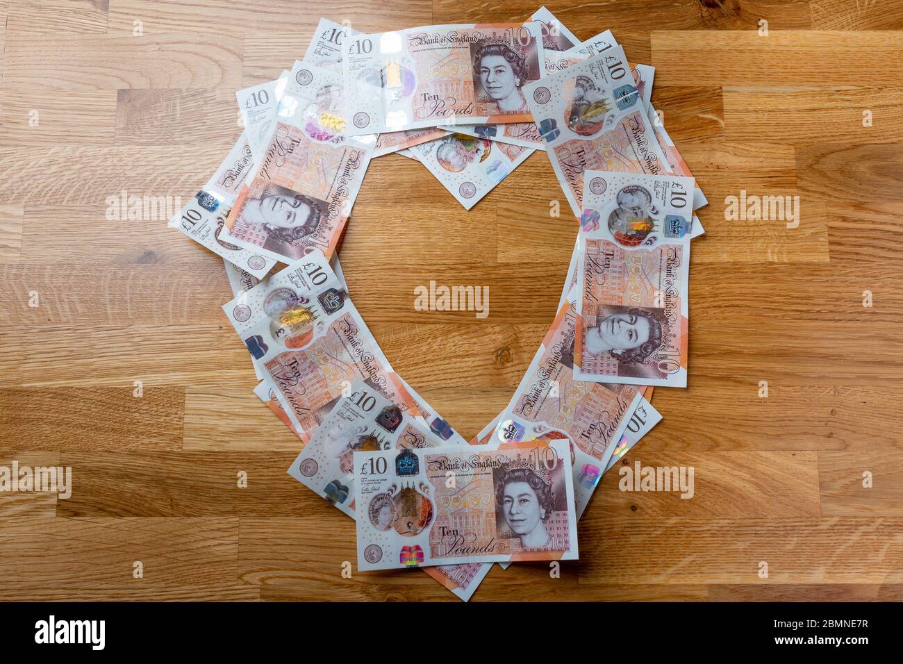 Dieci banconote da libbra a forma di cuore, in contanti sterling britannico Foto Stock