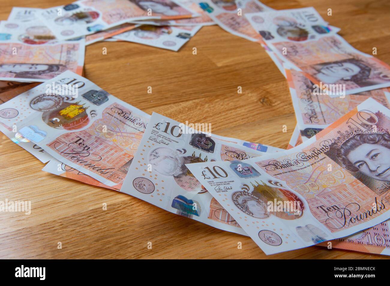 Dieci banconote da libbra a forma di cuore, in contanti sterling britannico Foto Stock