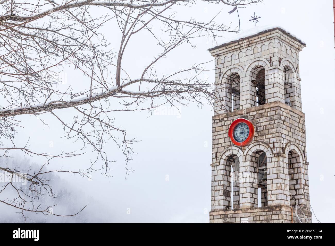 Paesaggio invernale con campanile di una chiesa cristiana ortodossa, nel villaggio di Mikro Chorio, vicino a Karpenissi, nella Grecia centrale, in Europa. Foto Stock
