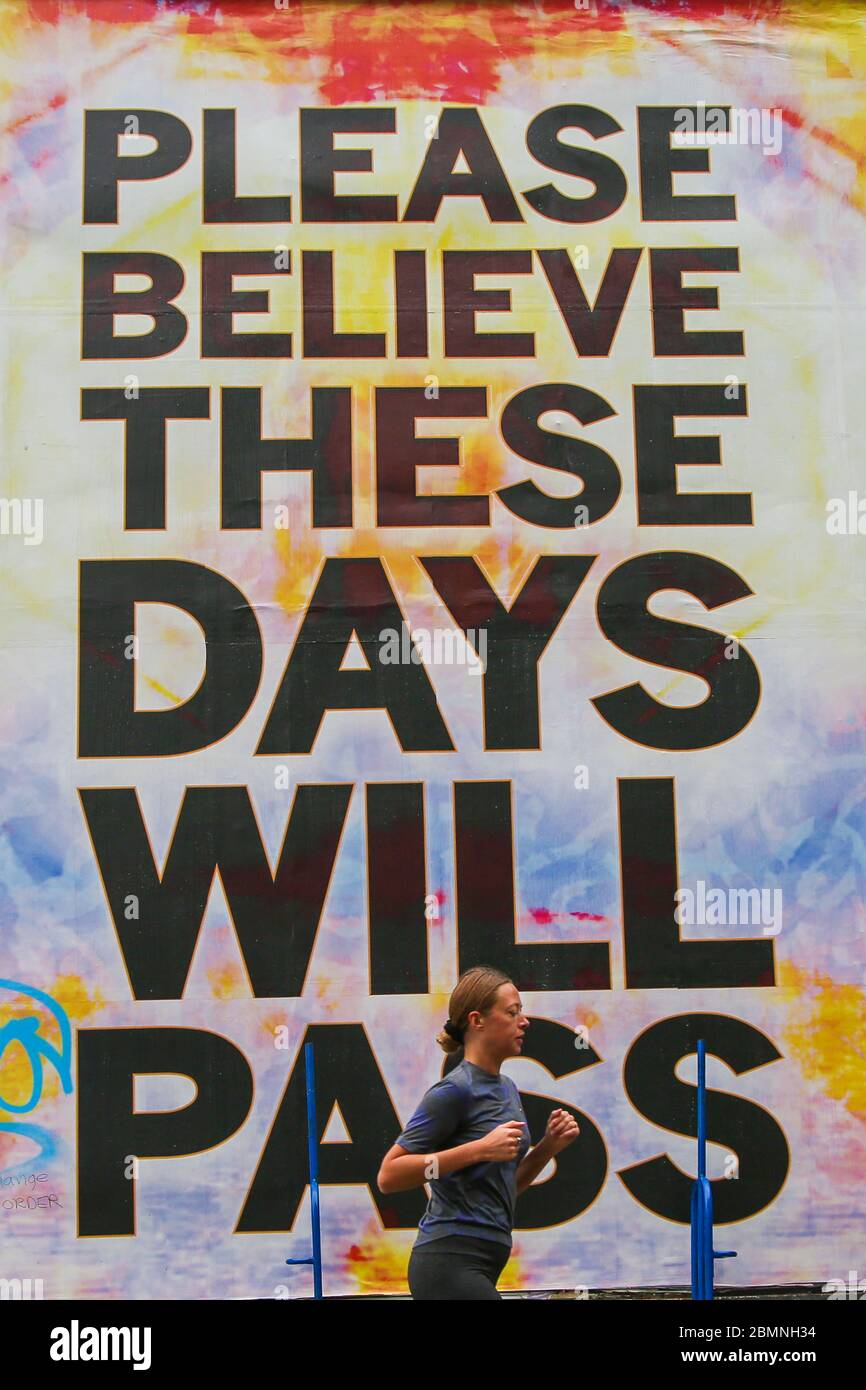 Londra, Regno Unito. 10 maggio 2020. Una donna prende il segno di un poster di Mark Titchner "Please Believe These Days Will Pass" a Londra. Credit: Steve Taylor/SOPA Images/ZUMA Wire/Alamy Live News Foto Stock