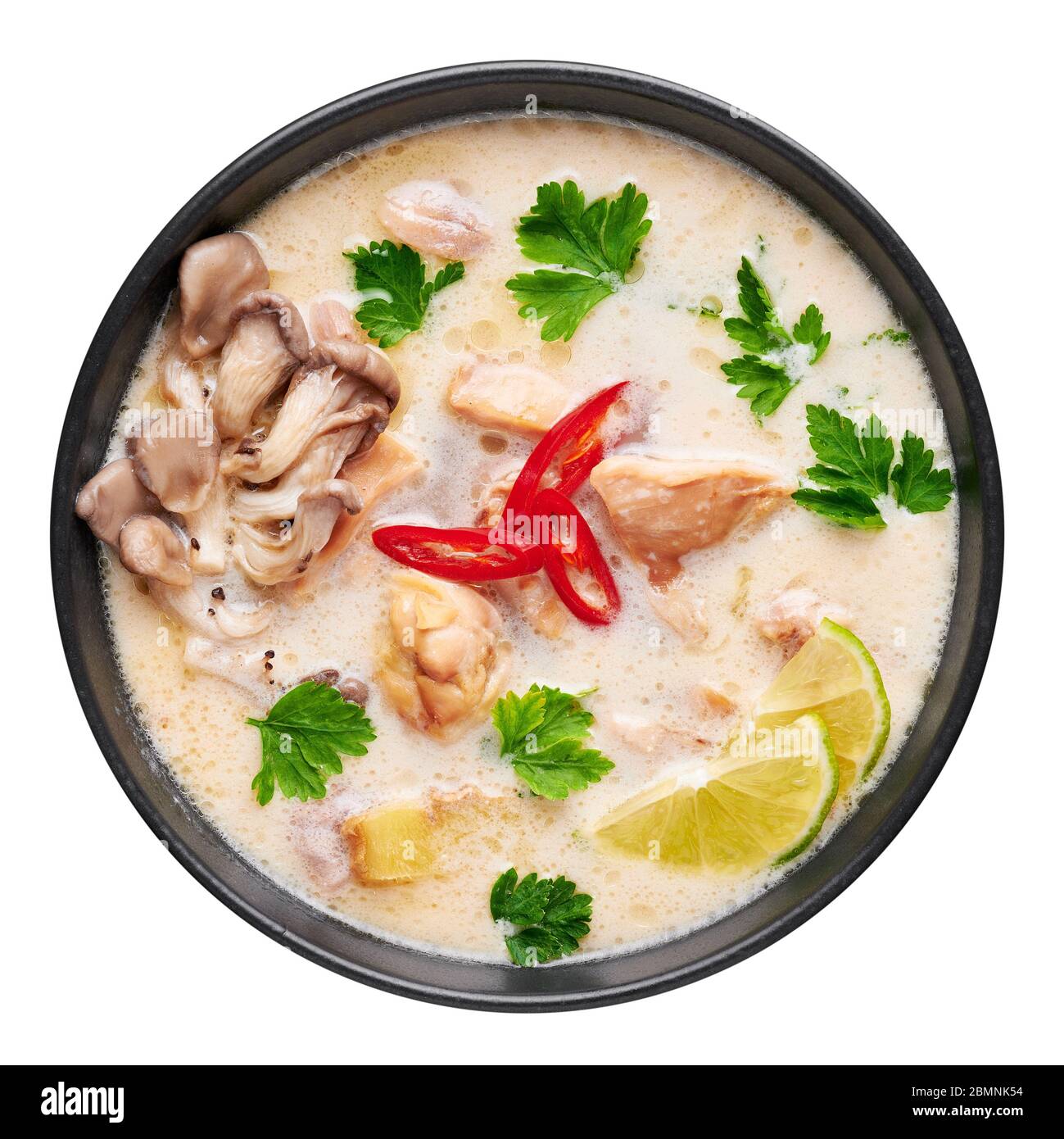 Tom Kha Gai o zuppa di pollo al cocco tailandese in ciotola nera isolata su sfondo bianco. Tom Kha Gai è piatto della cucina tailandese con latte di cocco, pollo, ga Foto Stock