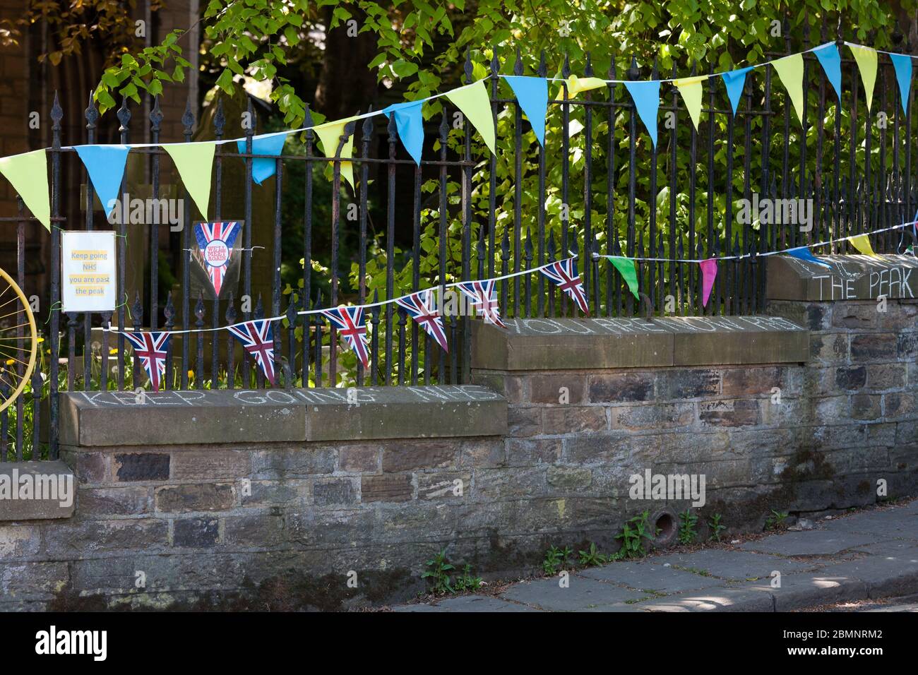 Holmfirth, UK - 7 maggio 2020: Un messaggio recita 'Keep going NHS you are apast the peak' sotto VE Day bunting in West Yorkshire. Foto Stock