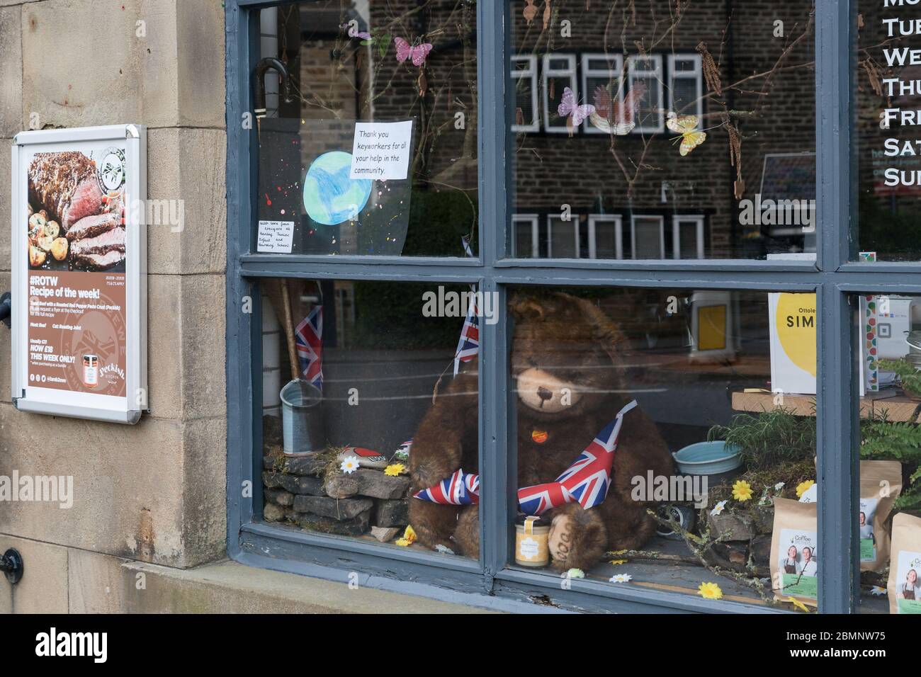 Una vetrina con un orsacchiotto e messaggi di sostegno per i lavoratori NHS a Honley Village, West Yorkshire Foto Stock