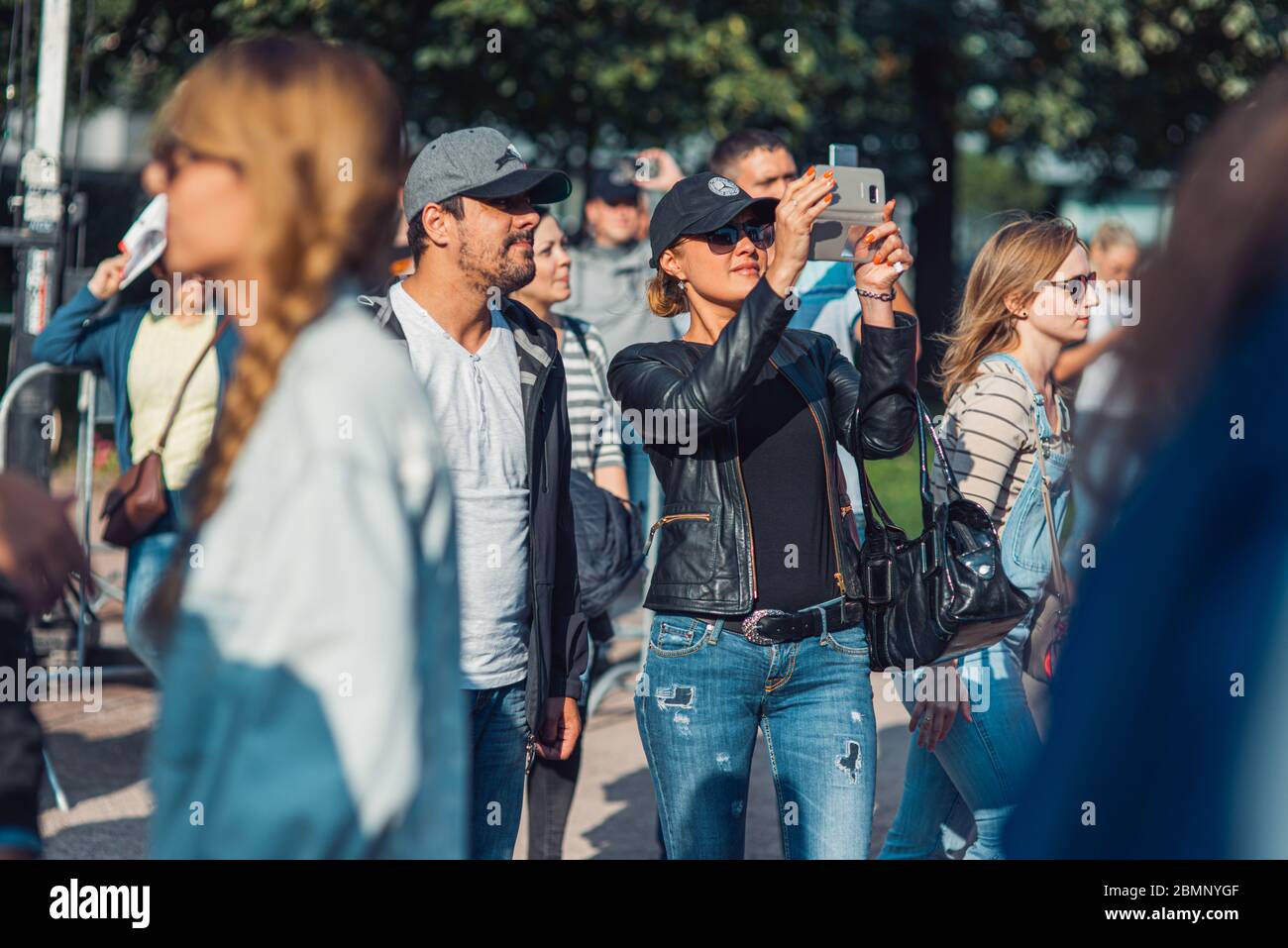 Mosca, Russia - 9 SETTEMBRE 2016: Una donna in una folla fotografa le viste della città al telefono utilizzando internet 5G Foto Stock