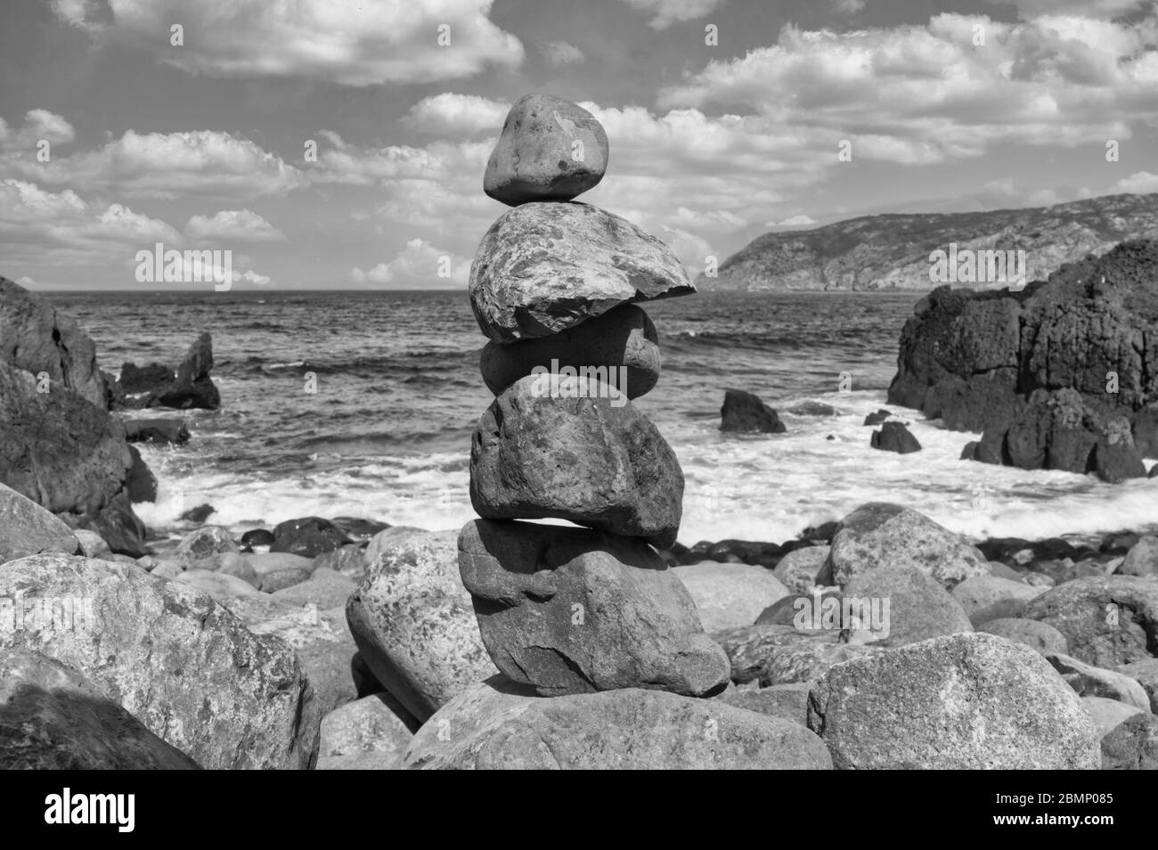 Rocce impilate su una spiaggia di ciottoli   B&W. Foto Stock
