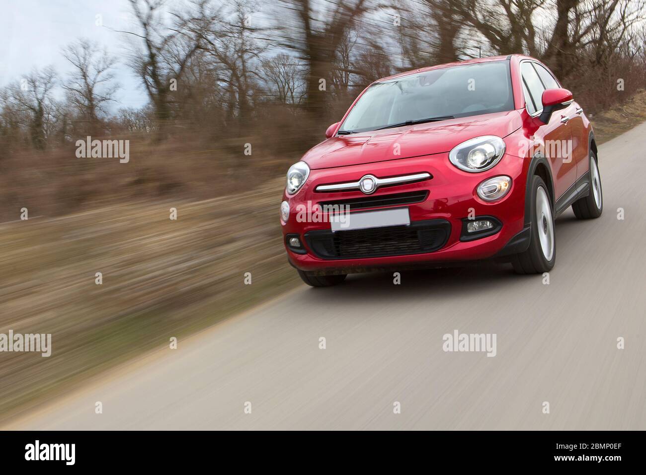 Una vettura rossa in rapida accelerazione con sfondo sfocato Foto Stock