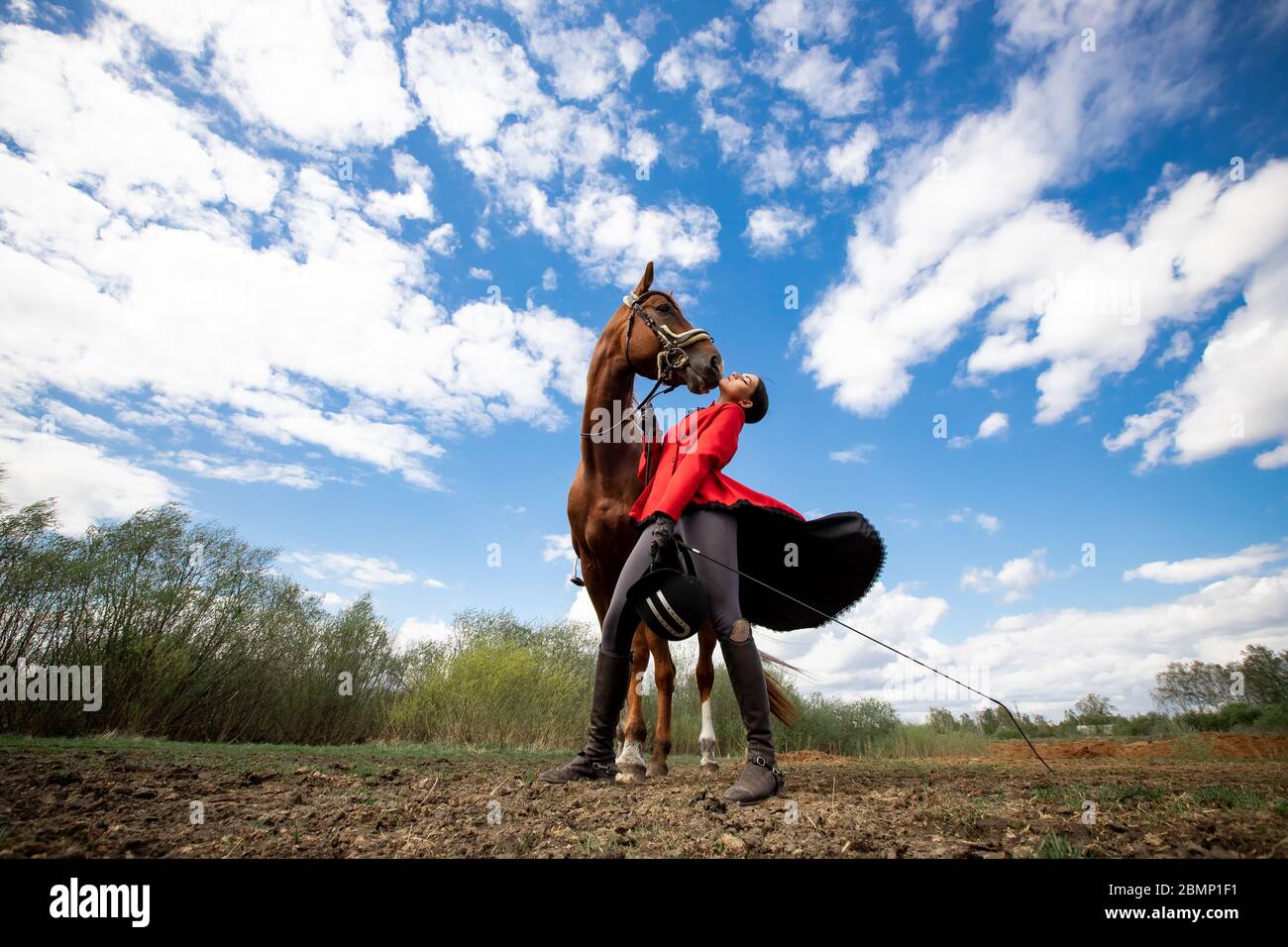 Moda foto Sport equestre Donna jockey con cavallo marrone, all'aperto. Foto Stock