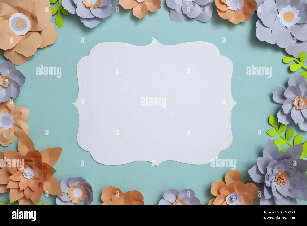 Disposizione piatta della cornice vintage della scheda, disegno di fiori di carta a colori su sfondo blu. Vista dall'alto, spazio copia, arte floreale Foto Stock