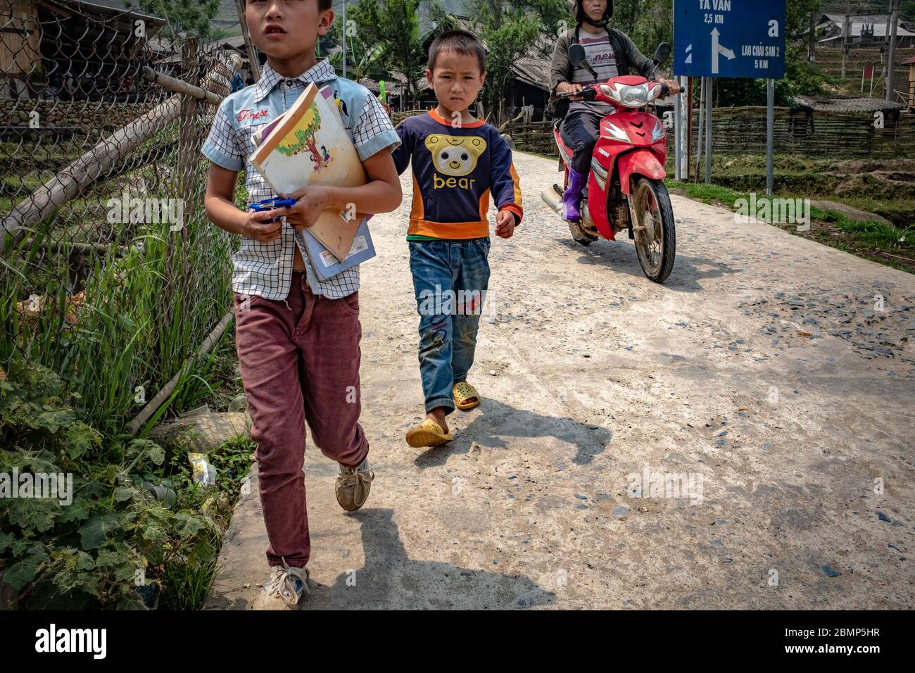 SA pa, Vietnam - 24 aprile 2018: Ragazzi vietnamiti in viaggio verso la scuola, indossando abiti casual ma colorati, presi in una giornata di overcast Foto Stock