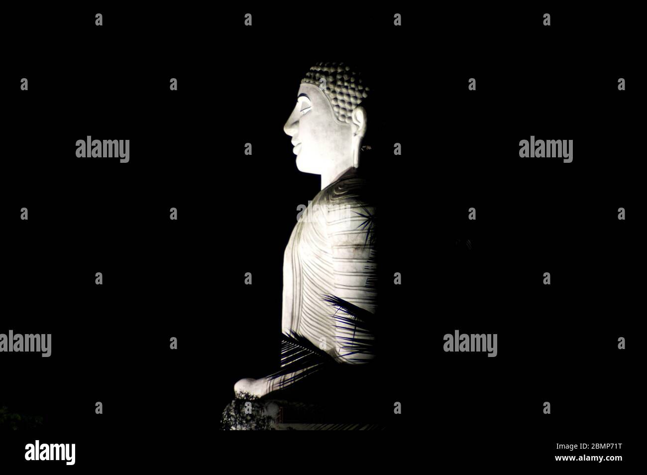 Una statua illuminata di buddha di signore a Kandy, Sri Lanka. Questa imponente statua in pietra è una delle principali attrazioni di Kandy. Foto Stock