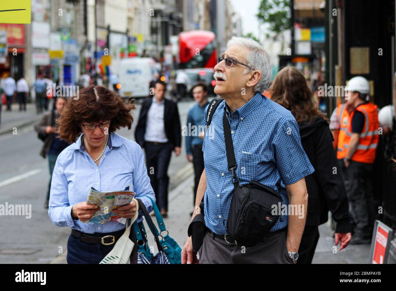 Coppie di turisti anziani che cercano di capire la loro posizione con la mappa e le indicazioni stradali a Londra, Inghilterra, Regno Unito, Gran Bretagna Foto Stock