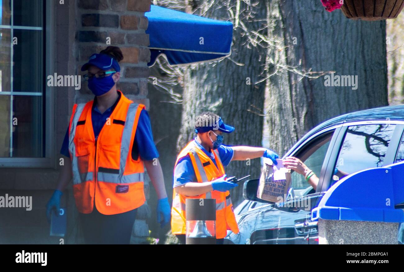 1 maggio 2020 Stevensville MI USA; i lavoratori indossano guanti e maschere per consegnare cibo a persone in auto che desiderano togliere cibo in questa stoppa chiusa Michigan Foto Stock