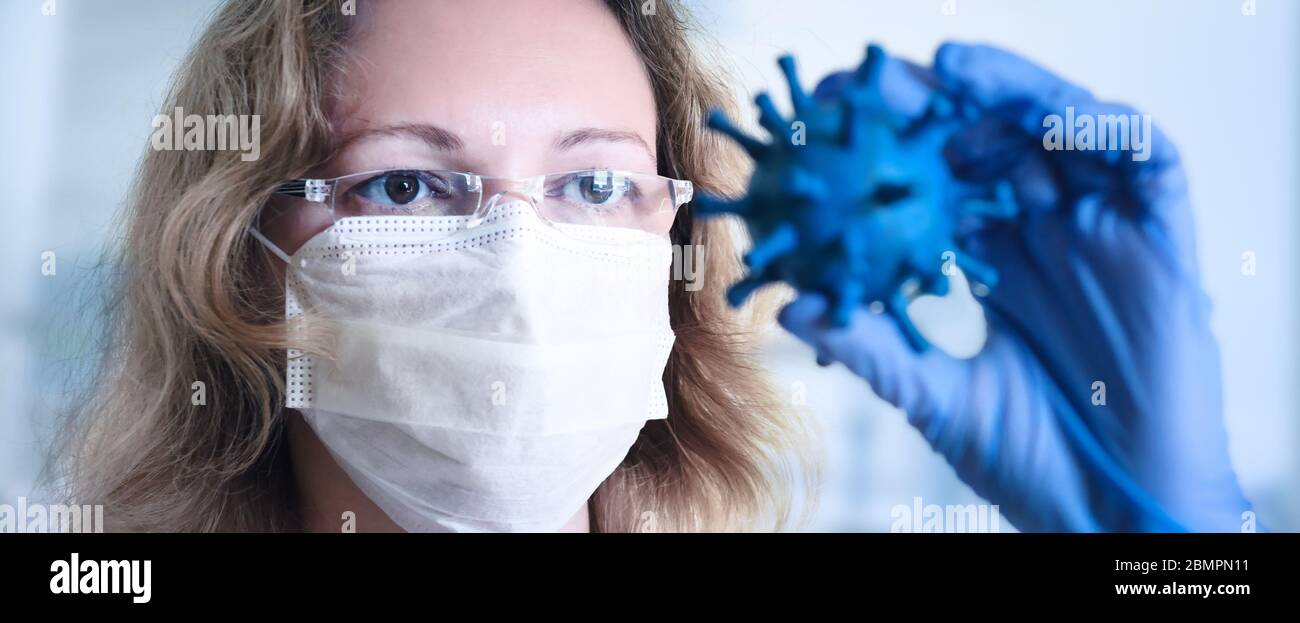 COVID-19 e Science Concept, banner panoramico con ricercatore in maschera guardando il coronavirus, focalizzazione sugli occhi. Ricerca medica del virus corona, develo Foto Stock