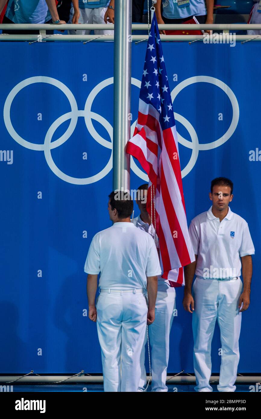 La bandiera degli Stati Uniti viene sollevata per la vittoria della medaglia d'oro di Amanda Beard vince il colpo di sterro femminile di 200 metri ai Giochi Olimpici estivi del 2004, Atene, Grecia. Foto Stock