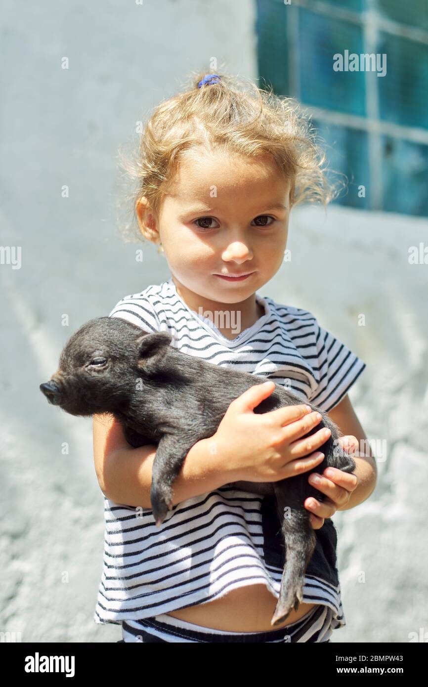 Bambina bambino tenendo in mano il bambino nero bambino neonato maialino  Foto stock - Alamy