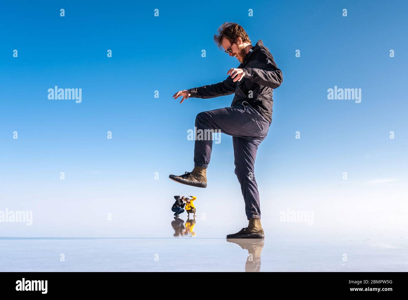 Prospettiva forzata dei giovani turisti alle Saline di Uyuni (in spagnolo: Salar de Uyuni) in Bolivia, Sud America. Foto Stock
