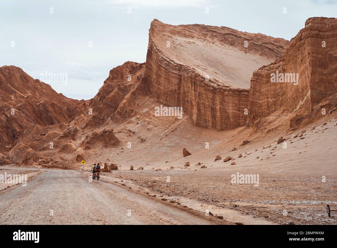 Ciclisti nella Valle della Luna (in spagnolo: Valle de la Luna) nel deserto di Atacama, Cile, Sud America. Foto Stock