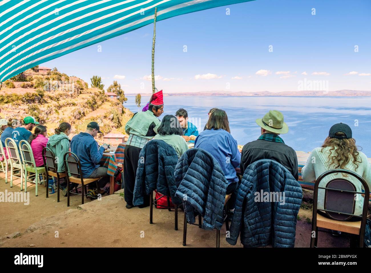 Gruppo di turisti che viene servito pranzo in un ristorante locale con una vista del Lago Titicaca, Taquile Island Perù Foto Stock