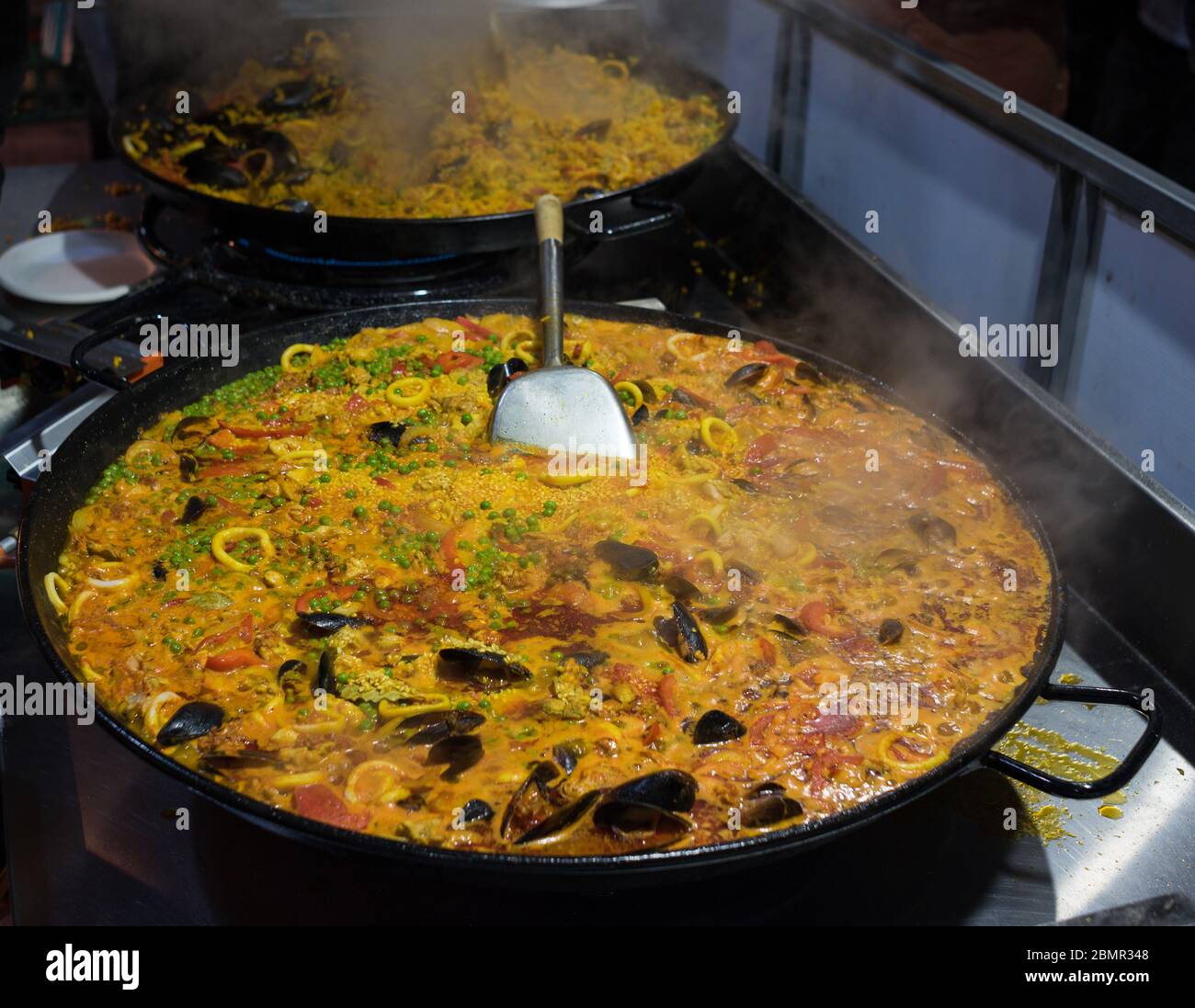 Paela in grande teglia in ghisa. Cucina spagnola, preparazione dei pasti al ristorante. Scena reale Foto Stock