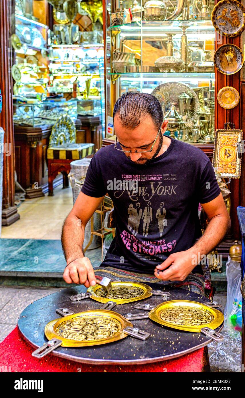 Artigiano al lavoro nel suo laboratorio all'aperto nel mercato di Khan el-Khalili nel quartiere islamico del Cairo, Egitto Foto Stock