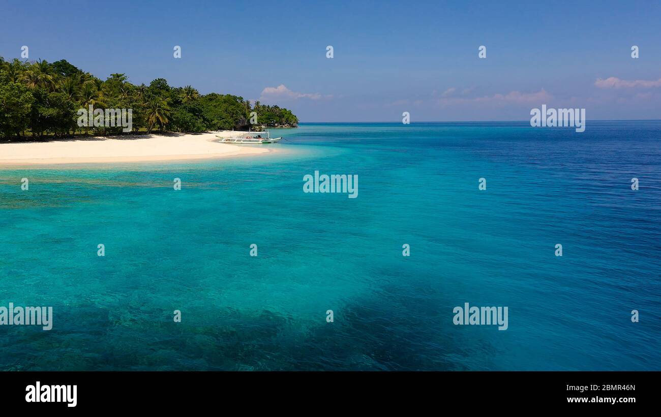Seascape con una bella isola tropicale, vista aerea. Una bellissima spiaggia di sabbia bianca. Mahaba Isola, Filippine. Mare blu con le lagune turchesi. Estate viaggi e concetto di vacanza. Foto Stock