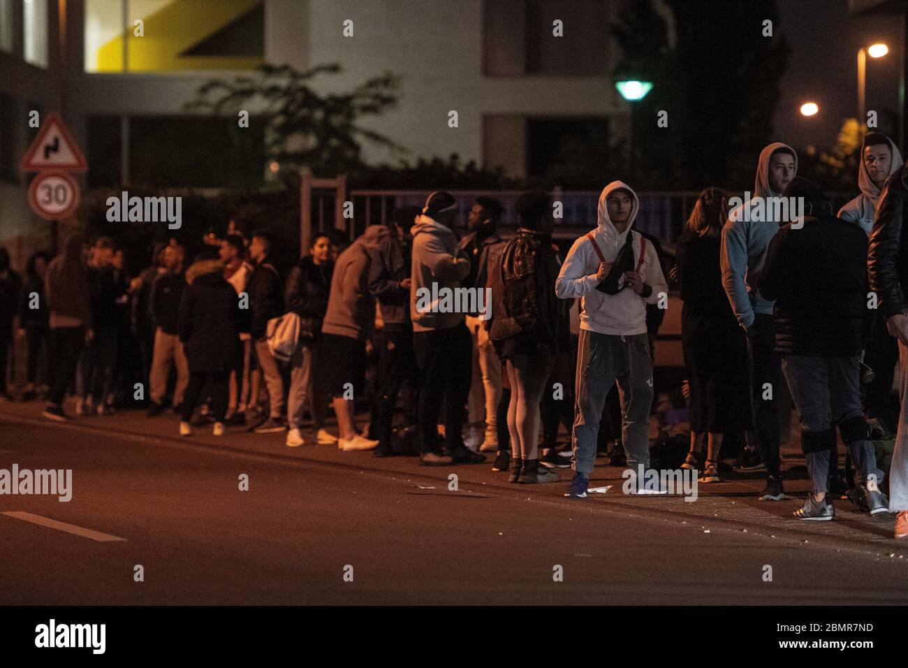 Colonia, Germania. 11 maggio 2020. Gli atleti si allineano poco prima di mezzanotte di fronte ad una palestra della catena McFit. A NRW, i primi studi fitness sono riaperti dopo la loro pausa corona di notte dal lunedì al lunedì. Credit: Marius Becker/dpa/Alamy Live News Foto Stock