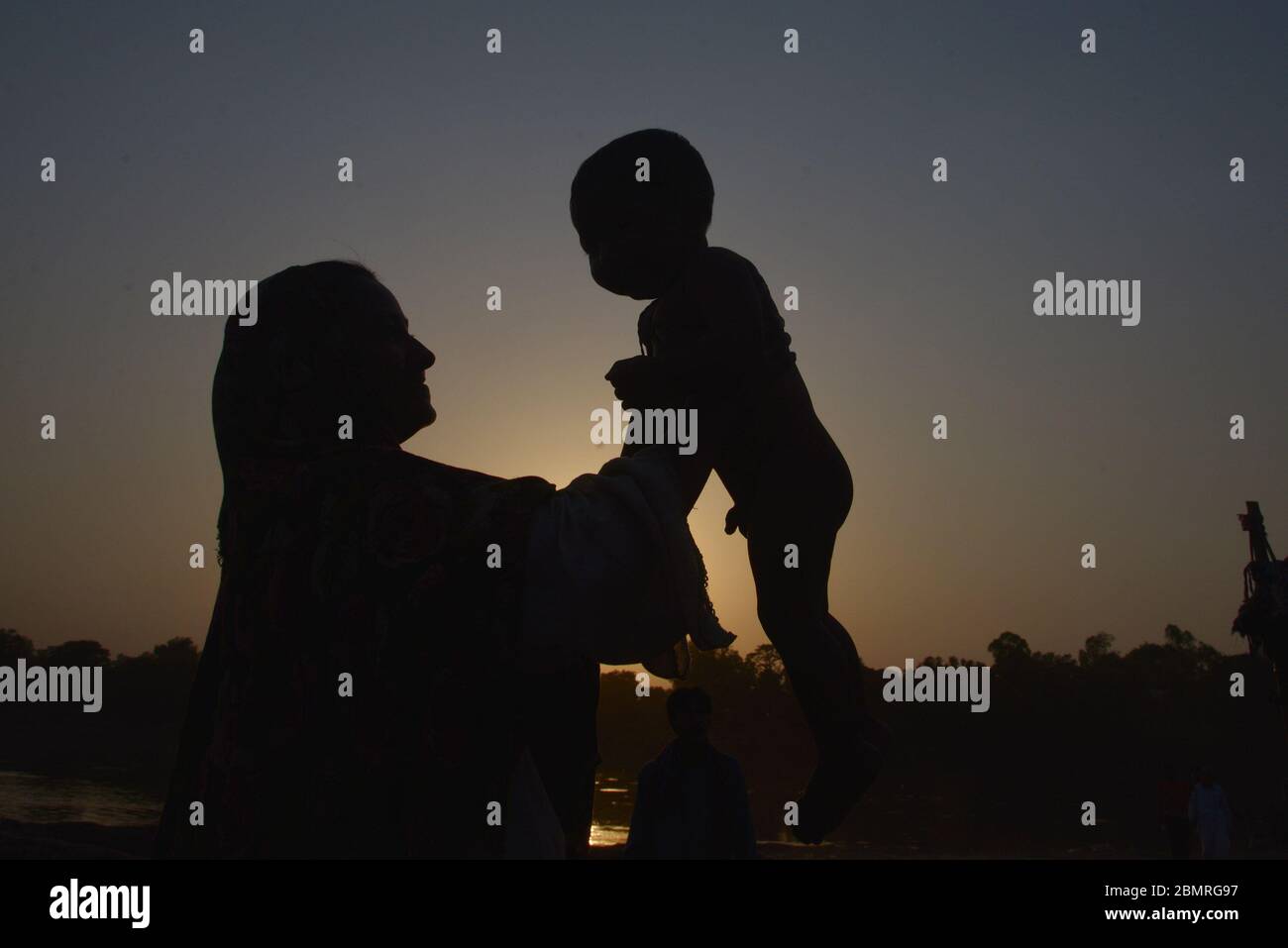 Lahore, Pakistan. 10 maggio 2020. La madre pakistana sta giocando ed esprimendo affetto al suo bambino alla vigilia della giornata delle madri sulla riva del fiume Ravi a Lahore. La Giornata della mamma si celebra ogni anno la seconda Domenica di Maggio Globally.Pakistan insieme ai loro bambini, è una celebrazione che onora la madre della persona, così come la maternità, i legami materni, e l'influenza delle madri nella società. La Festa della mamma è nata principalmente da due donne, Julia Ward Howe e Anna Jarvis. Credit: Pacific Press Agency/Alamy Live News Foto Stock