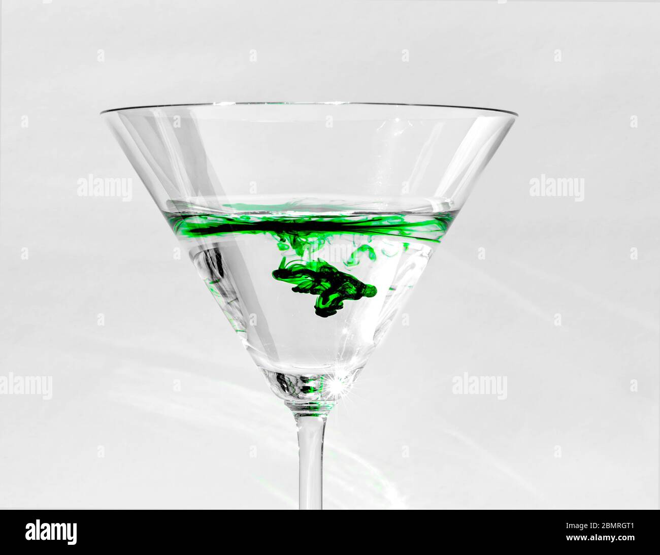 Una goccia di colore verde brillante separata dall'acqua in vetri trasparenti martini, Virginia, Stati Uniti, Nord America, colore Foto Stock
