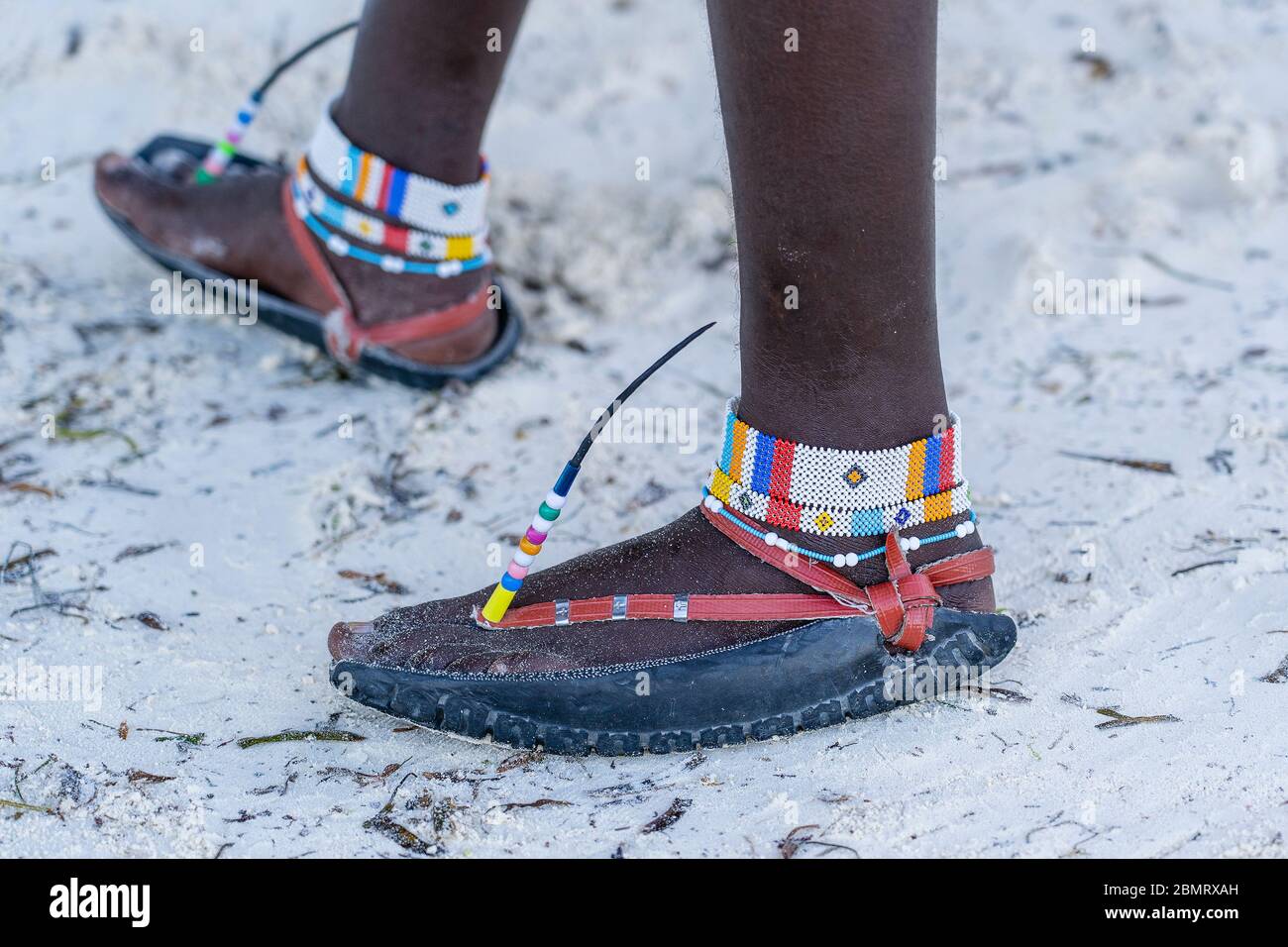 Gambe Tribal masai con un bracciale colorato e sandali fatti di pneumatici  auto sulla spiaggia di sabbia, primo piano. Isola di Zanzibar, Tanzania,  Africa Orientale Foto stock - Alamy