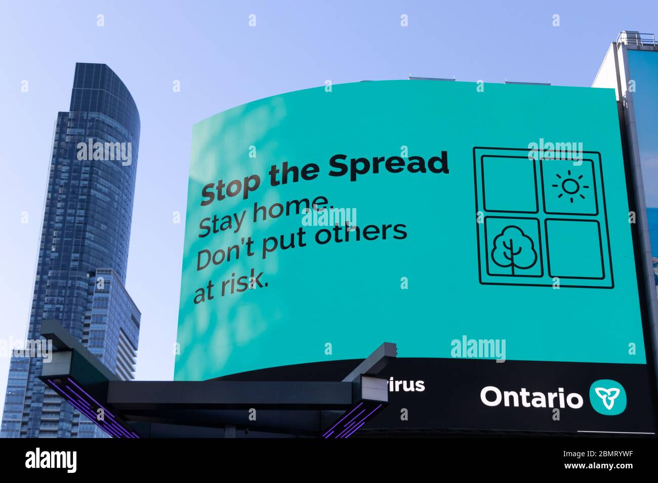 "Arrestare la diffusione. Rimani a casa. Non mettere a rischio gli altri". COVID-19 cartello informativo Coronavirus in Young-Dundas Square Toronto. Foto Stock