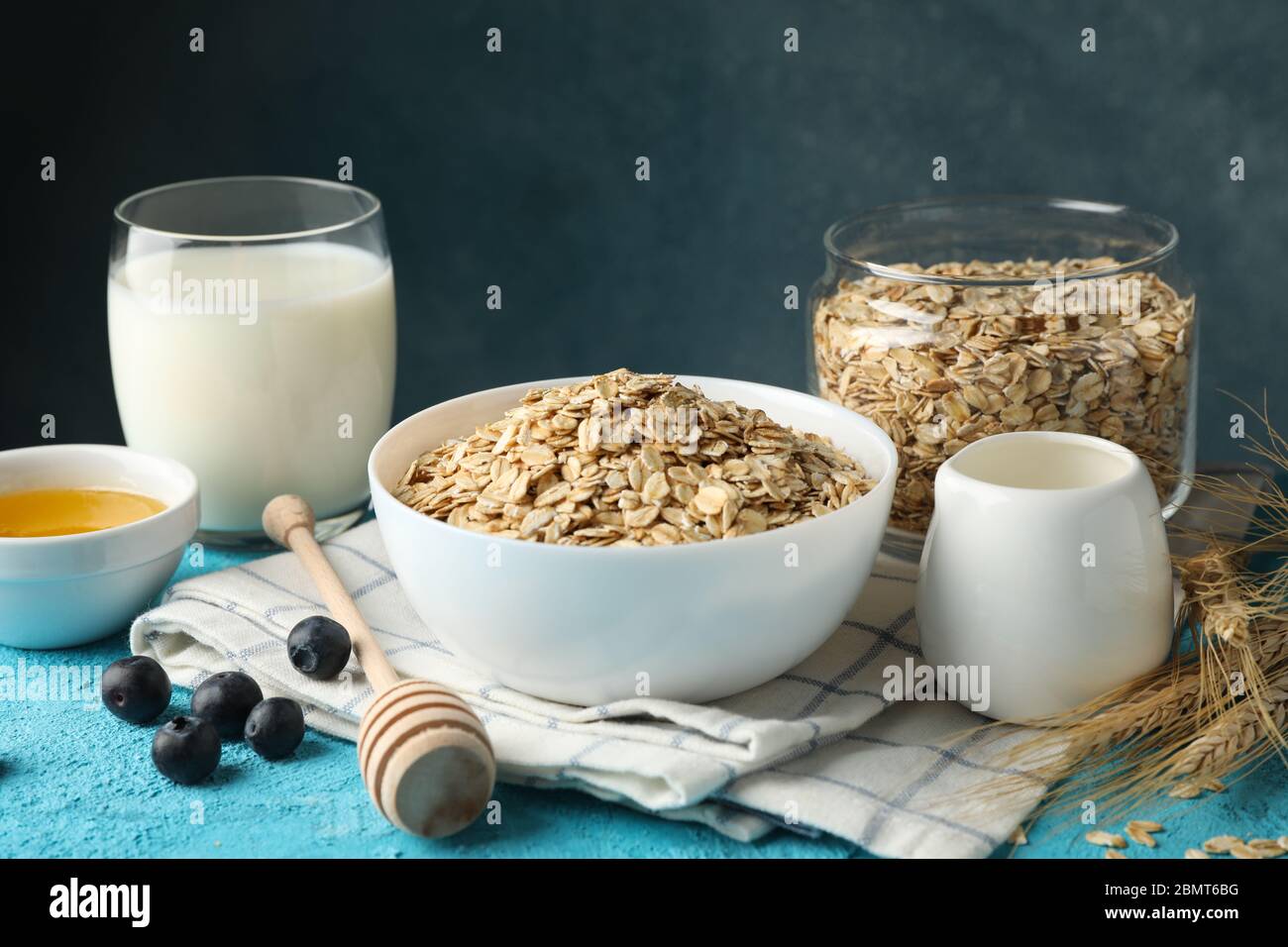 Composizione con fiocchi di farina d'avena su sfondo blu. Prima colazione  di cottura Foto stock - Alamy