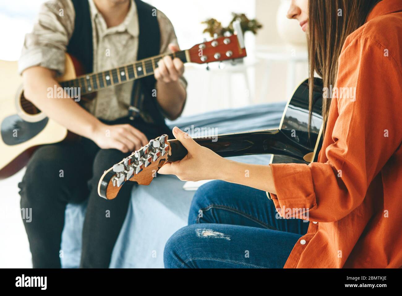 Imparare a suonare la chitarra. L'insegnante spiega allo studente le basi per suonare la chitarra. Lezioni individuali di scuola domestica o extracurricolare. Foto Stock