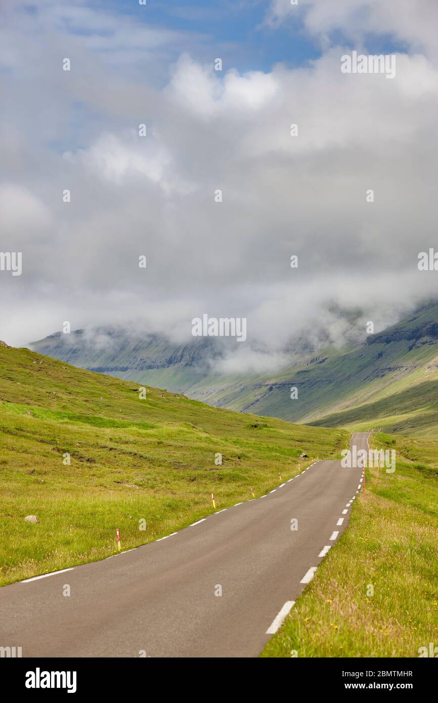 Isole Faerøer vecchia strada circondata dal verde paesaggio del fiordo. Danimarca Foto Stock