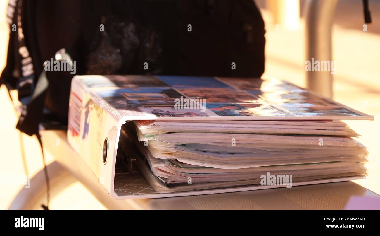 primo piano di una cartella di note di revisione della scuola studente autentica. Collaged con fotografie personali e riempito con maniche di plastica e l'esercitazione del soggetto Foto Stock