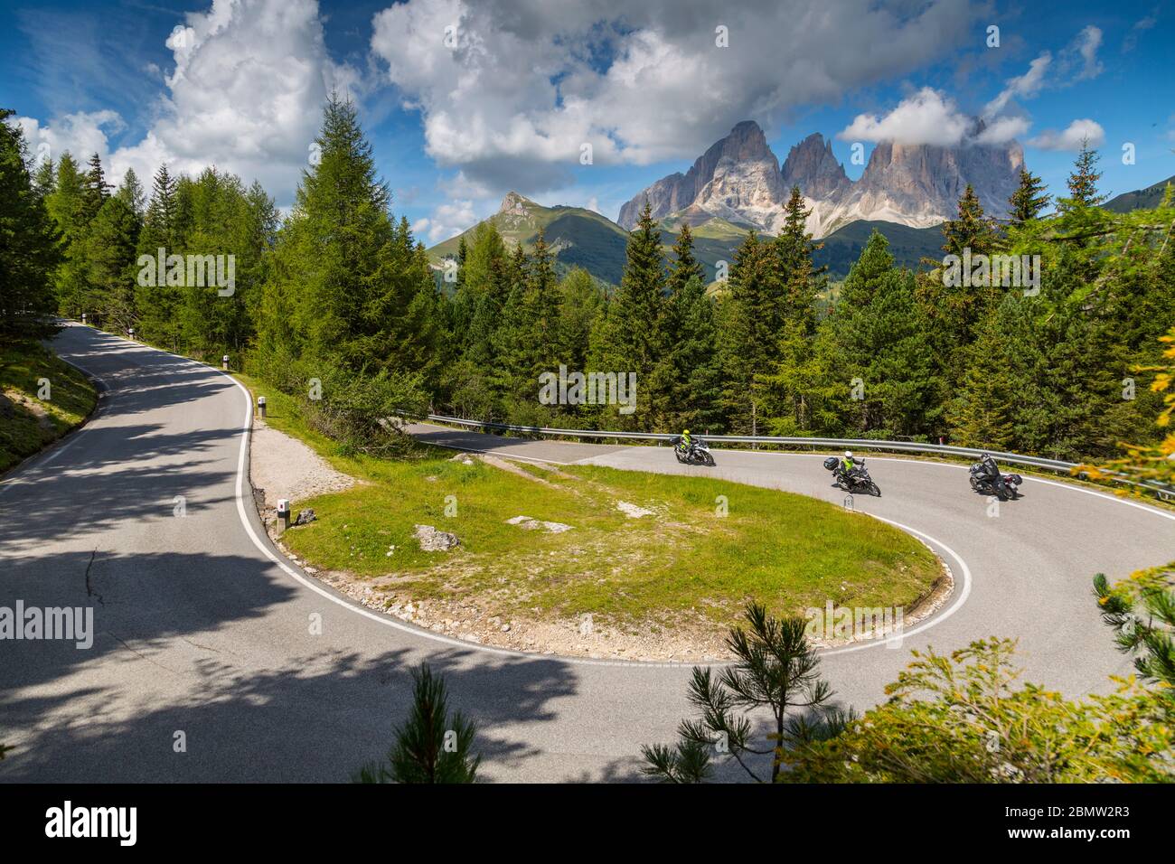 Motociclisti in curva sul Passo Pordoi con sfondo montano, Alto Adige, Dolomiti Italiane, Italia, Europa Foto Stock