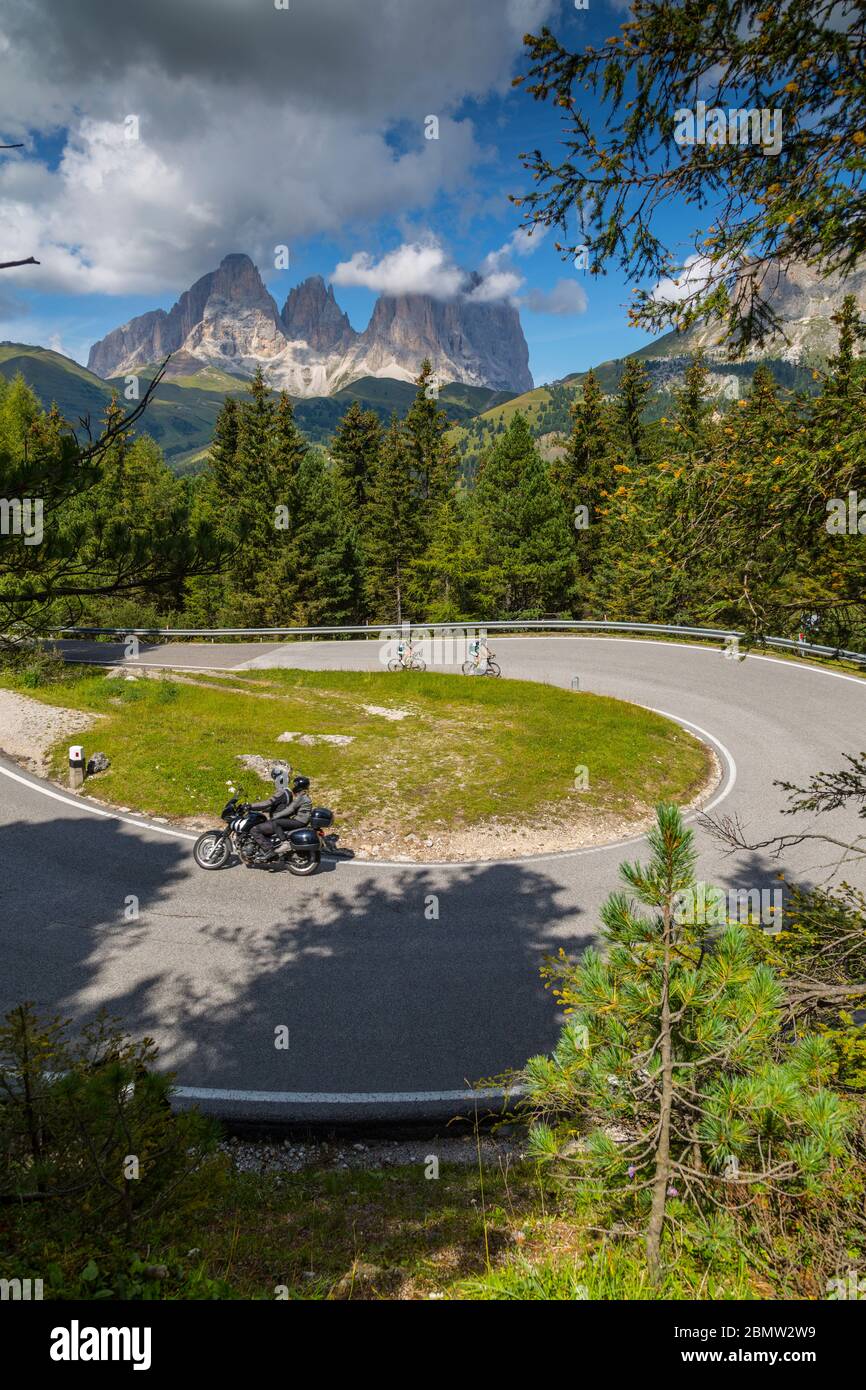 Ciclisti in curva sul Passo Pordoi con sfondo montano, Alto Adige, Dolomiti Italiane, Italia, Europa Foto Stock
