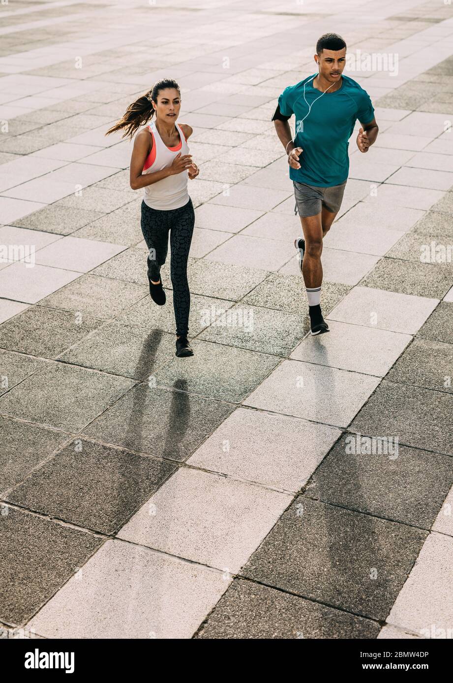 Coppia in allenamento sportivo insieme in città. Uomo e donna sportivi che corrono insieme in città. Foto Stock