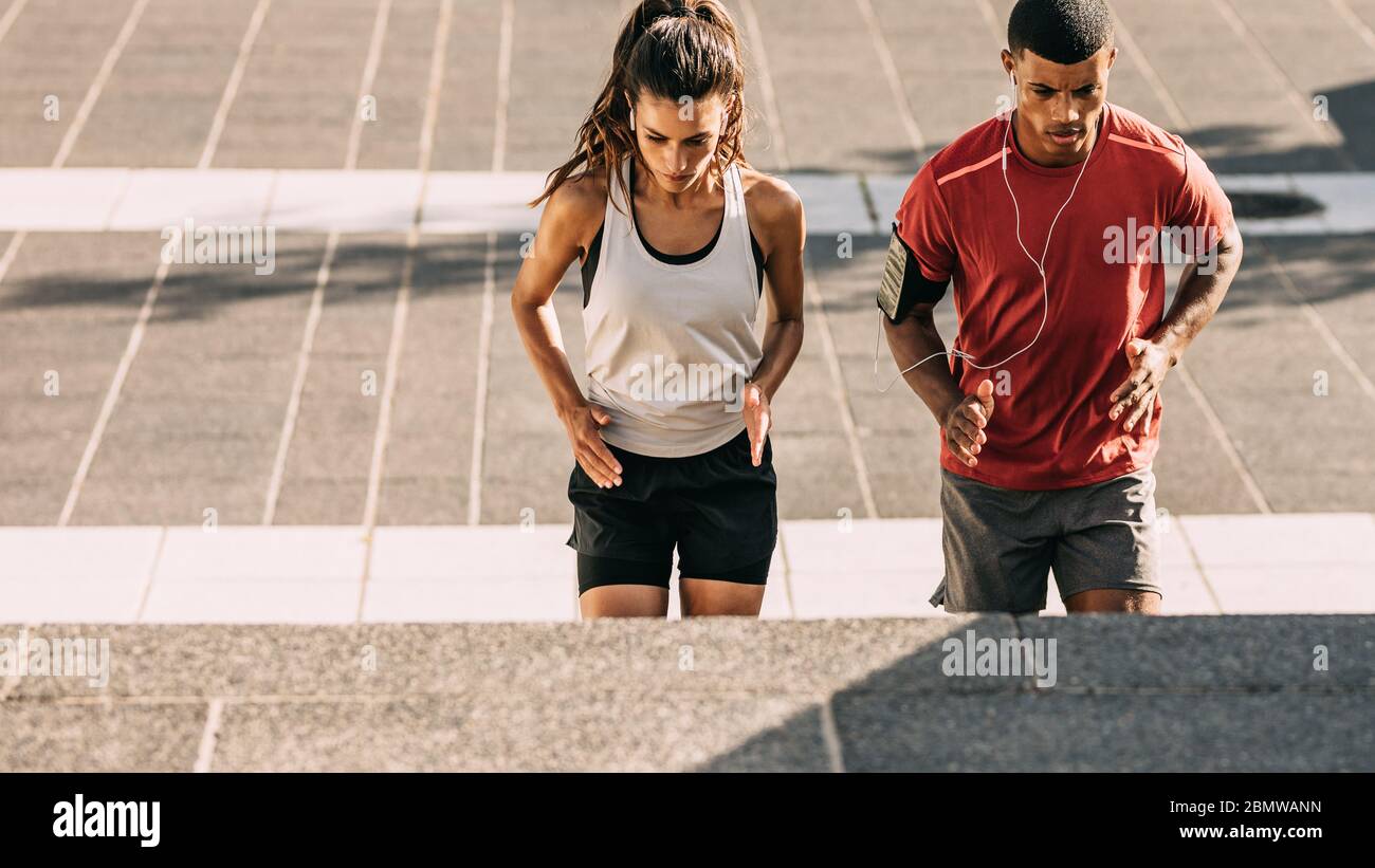 Coppia in allenamento sportivo insieme in città. Uomo e donna sportivi che si allenano insieme sui gradini della città. Foto Stock