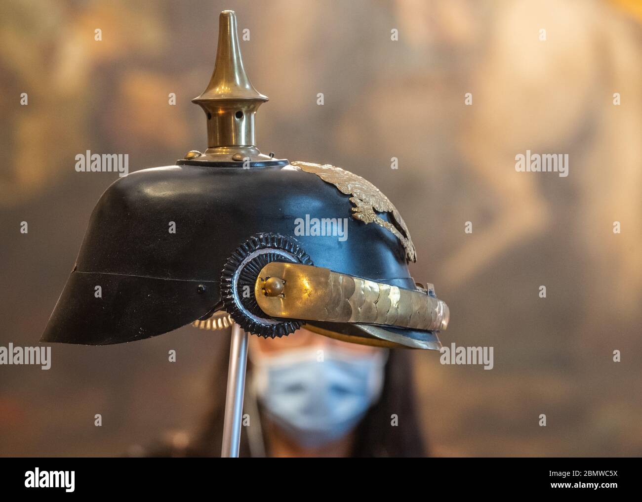 Moritzburg, Germania. 11 maggio 2020. Un visitatore che indossa una maschera facciale si trova nella mostra '350 anni del mito di agosto il forte - Storia. Potenza. Tu.' nel castello di Moritzburg dietro un casco a chiodata. Con questa mostra, Schlösserland Sachsen celebra il 350° compleanno dell'ex elettore, nato il 12 maggio 1670. Credit: Robert Michael/dpa-Zentralbild/dpa/Alamy Live News Foto Stock