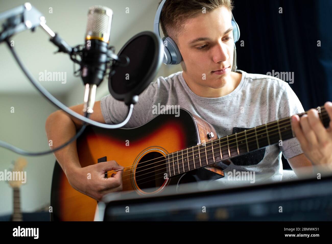Ragazzo adolescente a suonare la chitarra e la registrazione di musica a casa Foto Stock