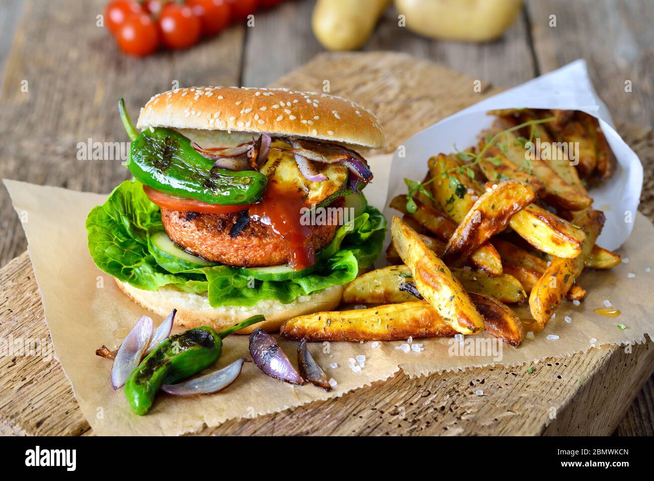 Cibo da strada senza carne - delizioso hamburger vegetariano con patatine di soia e verdure alla griglia, servito con zeppe di patate Foto Stock