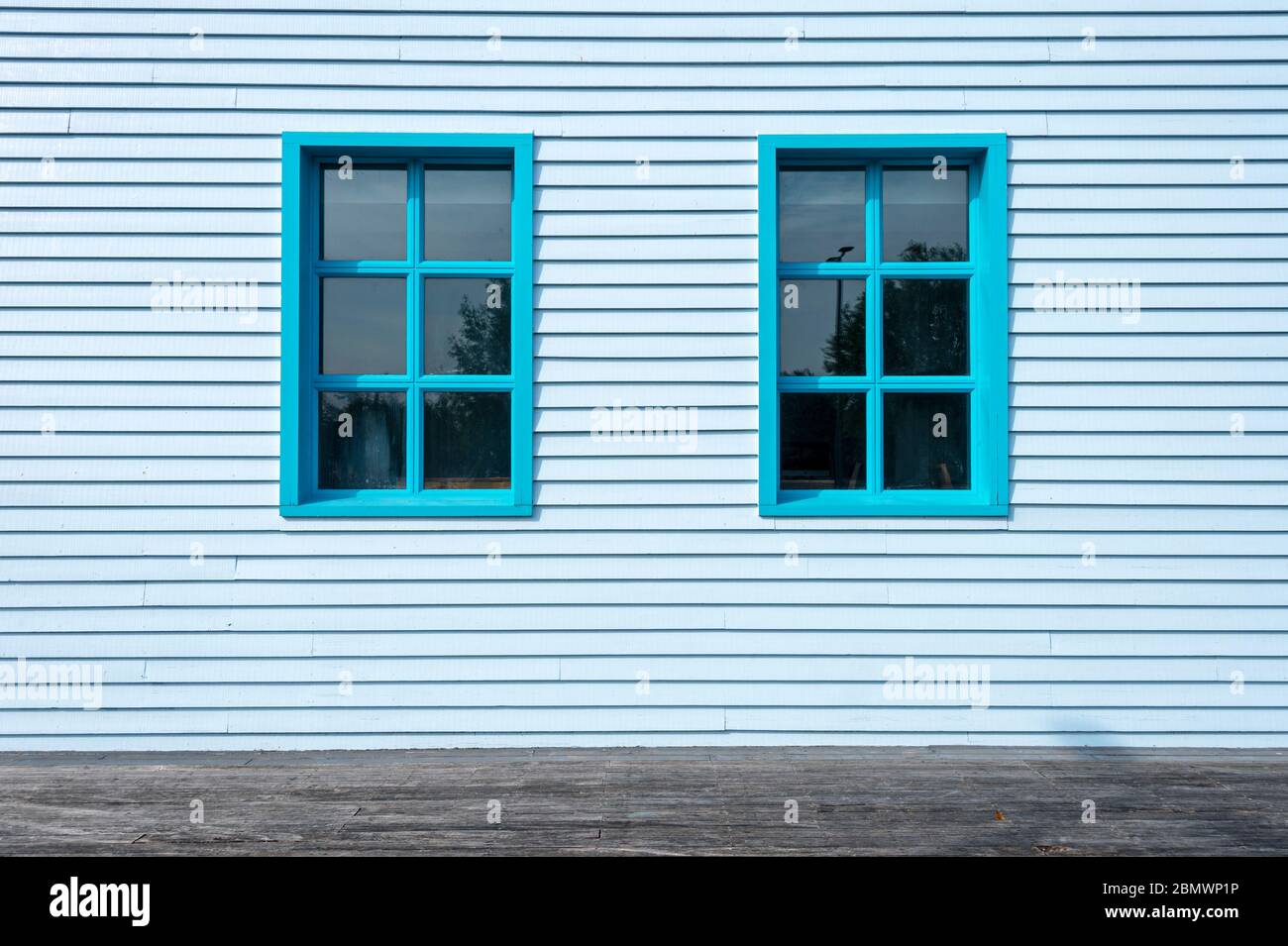 esterno di un edificio dipinto di blu con due finestre. Foto Stock
