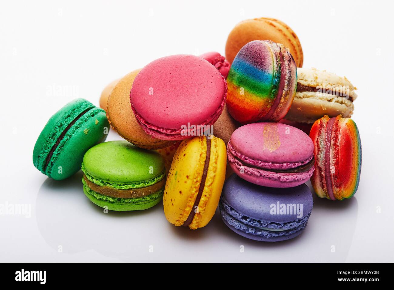Macaron multicolore piegato in una pila su uno sfondo bianco Foto Stock